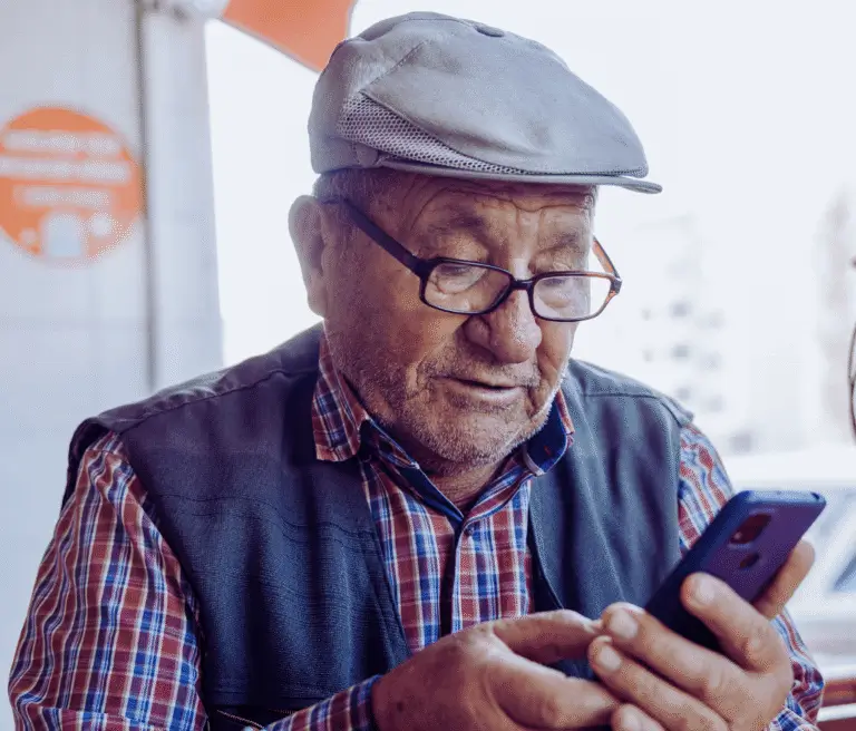 Older man wearing a cap looking at a smartphone