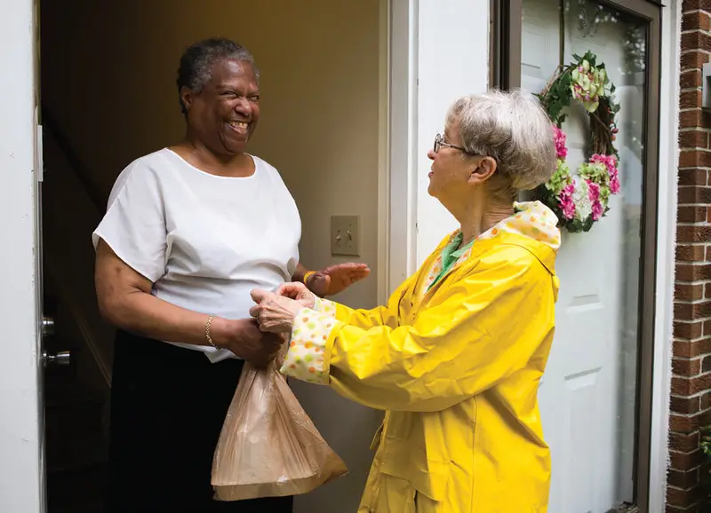 Two women greeting at a doorway