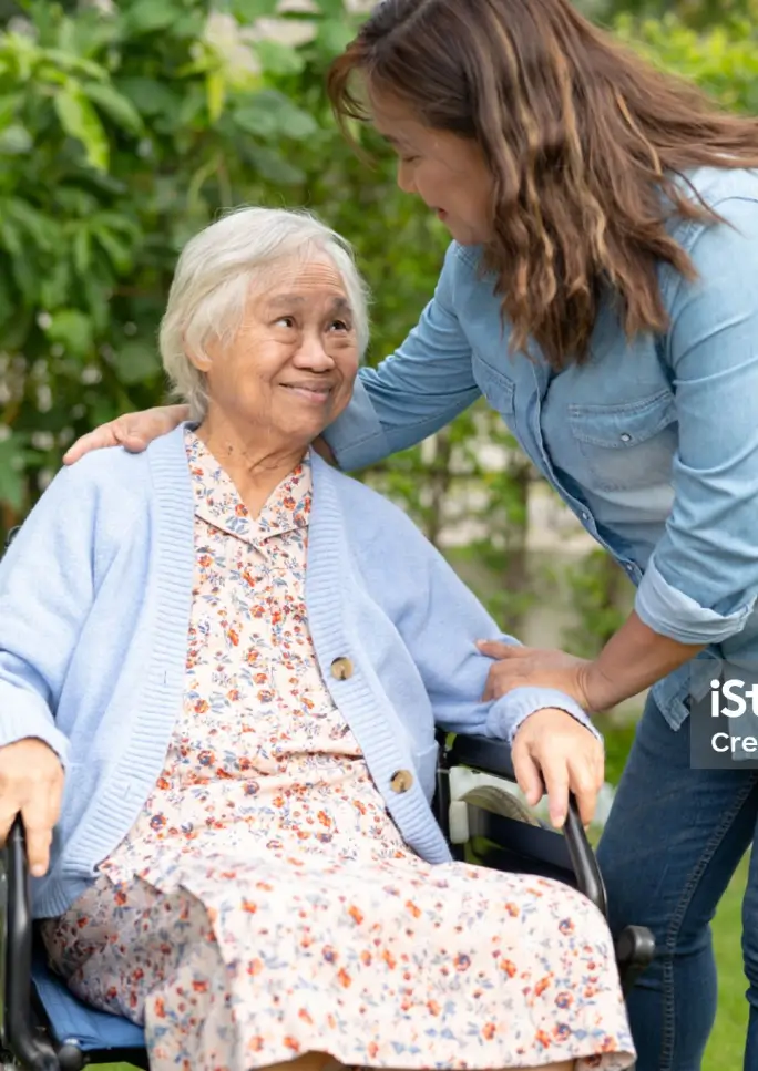 Caregiver assisting an elderly woman outdoors
